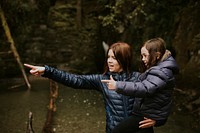 Family camping trip mother holding daughter in her arms while pointing their fingers