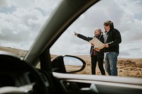 Senior tourist couple looking at the map while being lost in Wales, UK