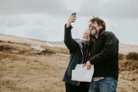 Senior happy couple taking selfies in Wales, UK