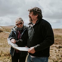 Senior tourist couple looking at the map while being lost in Wales, UK