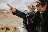 Senior tourist couple looking at the map while being lost in Wales, UK