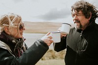 Senior camper couple having morning coffee in the countryside