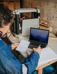 Laptop screen mockup psd on the table in a wood workshop 