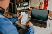 Laptop screen mockup psd on the table in a wood workshop 