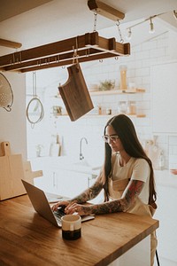 Tattooed woman in her 30s work from home 