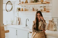 Tattooed woman in kitchen in a phone call