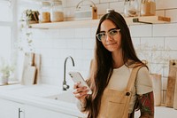 Lifestyle blogger using her mobile phone in the kitchen