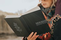 Book cover mockup held by a senior woman outdoors