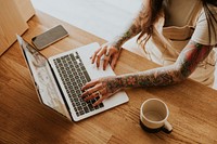 Tattooed woman working on her small business at home