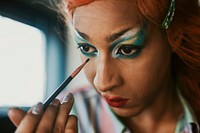 Man in drag applying eyeshadow, entertainment makeup look