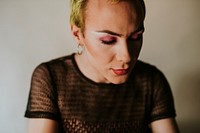 Blond non-binary person wearing makeup portrait