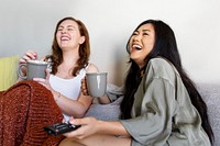 Roommates laughing out loud on the sofa