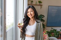 Woman drinking wine alone at home