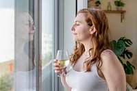 Woman drinking wine alone at home