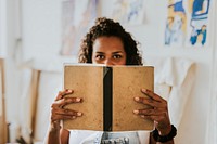 Woman artist reading and studying in her studio 