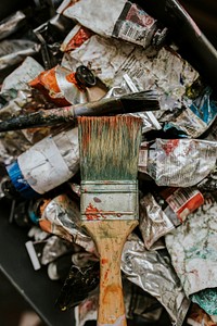 Paint brush on piles of paint tube 