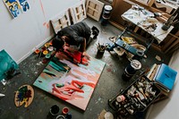 Woman artist working on her paint canvas in her studio 