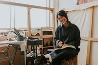 Woman artist reading and studying in her studio 