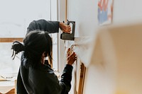 Artist attaching a fabric canvas to the wall