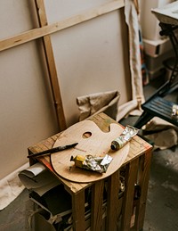 Artist's tools including color palette and paint brush on a wooden table 