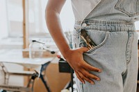 Artist with paint brush in her overall pocket 