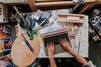 Artist working on her laptop in her studio 