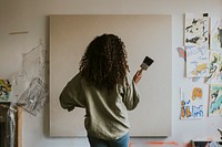 Woman artist painting on a big blank canvas