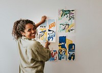 Woman artist putting her abstract artwork on the mood board wall 