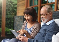 Senior couple using a tablet in the patio
