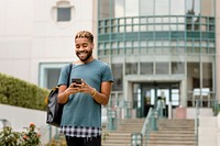Happy student checking mobile phone at campus