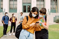 Friends checking social media on phone at school