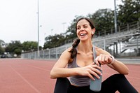 Happy woman athlete drinking water and rest 