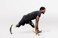 Paralympic athlete with prosthetic legs warming up by stretching before exercising