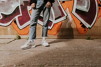 Man standing by a graffiti wall in a city