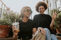 Two friends sitting and talking while having a coffee 