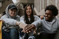 Diverse friends staking hands in the middle