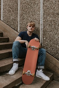 Blond skate sitting on steps with dulled orange skateboard