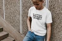 Blond man in white tee and jeans standing by stairs