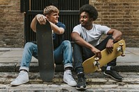 Diverse skaters sitting on sidewalk