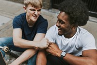 Diverse friends fist bumping, on sidewalk