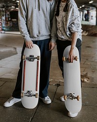 Couple with white skateboards at skate park