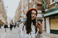 Mixed race woman using phone in city