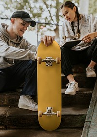 Friends talking about yellow skateboard in hand