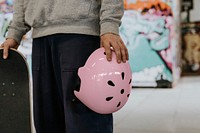 Skater holding pink skate helmet, sports safety equipment