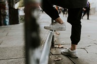 Man rest foot on street railing