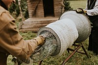 People wrapping a Christmas tree using the tube machine at a Christmas tree farm 