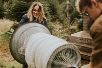 Man and woman wrapping a Christmas tree using the tube machine at a Christmas tree farm 