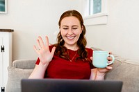 Woman working from home, waving during online meeting image