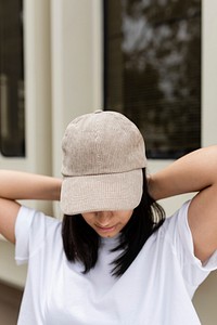 Woman in white tee, wearing beige cap