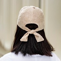 Woman in white tee, wearing beige cap, rear view